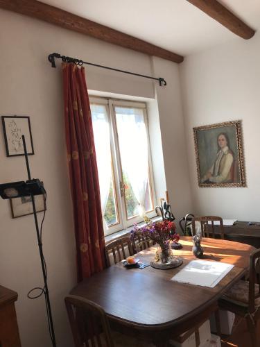 a dining room with a wooden table and a window at hilltop villa garden with great views in Poggio Catino