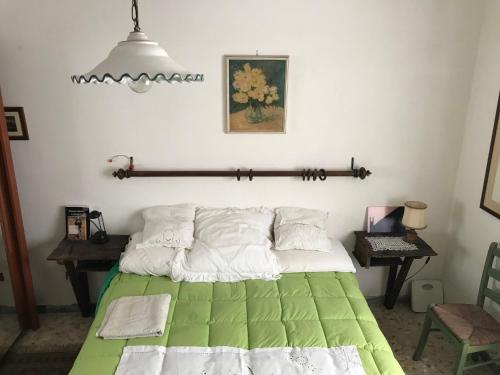 1 dormitorio con 1 cama con edredón verde y blanco en hilltop villa garden with great views en Poggio Catino