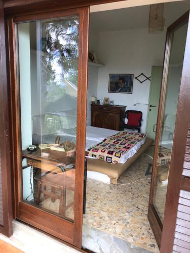 a bedroom with a bed and a glass door at hilltop villa garden with great views in Poggio Catino