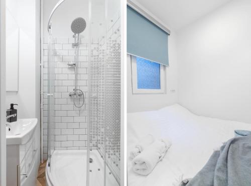 bagno bianco con doccia e lavandino di Ultra Central, 15 sqm studio a Bucarest