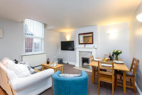 a living room with a couch and a dining room at Bedzzz - Booklovers Dream in Preston