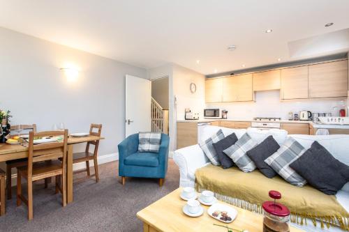 a living room and kitchen with a couch and a table at Bedzzz - Booklovers Dream in Preston