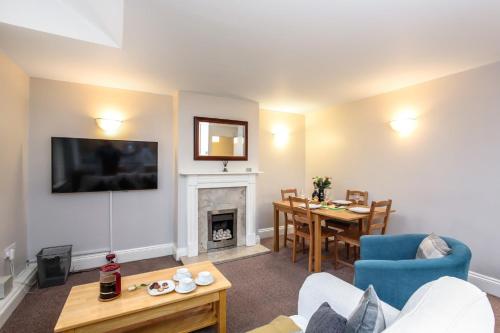 a living room with a couch and a table and a fireplace at Bedzzz - Booklovers Dream in Preston