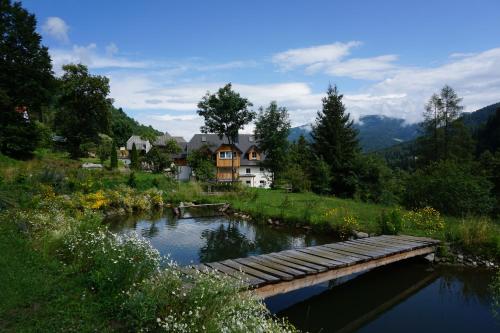 a bridge over a river in front of a house at Vitalhof am Kreischberg by ALPS RESORTS in Bodendorf