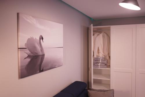a living room with a picture of a swan on the wall at Apartament Augustów SWAN in Augustów