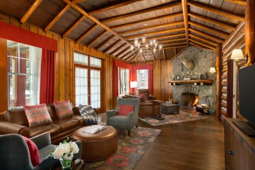 a living room with leather furniture and a stone fireplace at Fairmont Jasper Park Lodge in Jasper