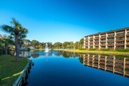 a view of a river with a building and a palm tree at Island Club in Hilton Head Island