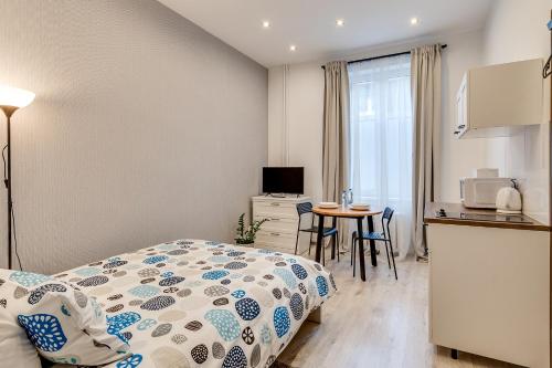 een slaapkamer met een bed en een keuken met een tafel bij KATO Apartamenty Moniuszki in Katowice