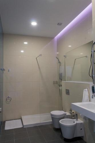 a bathroom with a shower and a toilet and a sink at Marketplace Apartment 1 in Ponta Delgada