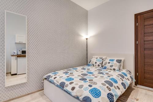 a small bedroom with a bed and a mirror at KATO Apartamenty Moniuszki in Katowice