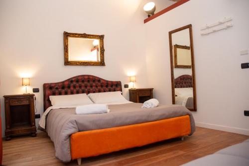 een slaapkamer met een groot bed en een spiegel bij Dillo Suites in Rome