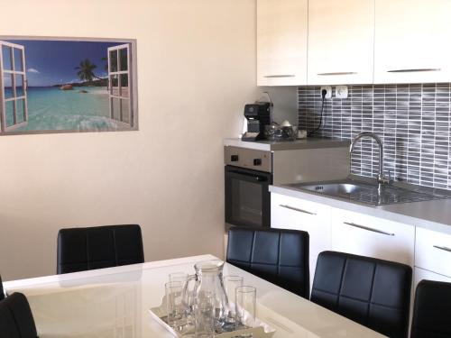 eine Küche mit einem Tisch mit Stühlen und einem Waschbecken in der Unterkunft Casa Sunshine - Casa Vacanze al mare in Punta Braccetto