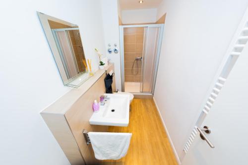 ein Badezimmer mit einem weißen Waschbecken und einem Spiegel in der Unterkunft City Apartment Reeperbahn Hamburg in Hamburg