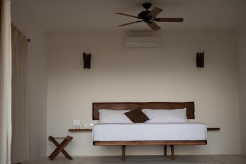 a bedroom with a bed with a ceiling fan at El Alquimista Yoga Spa in Zipolite