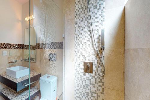 y baño con aseo y ducha acristalada. en Klem Residence, en Playa del Carmen