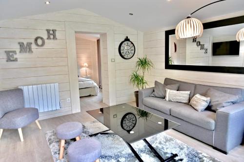 ein Wohnzimmer mit einem Sofa und einem Tisch in der Unterkunft Chalet cosy de Plage entre Biarritz et Hossegor in Tarnos