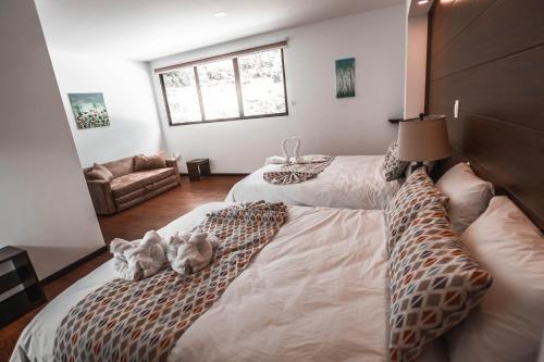 two stuffed animals sitting on a bed in a bedroom at Burbi Lake Lodge Monteverde in Monteverde Costa Rica