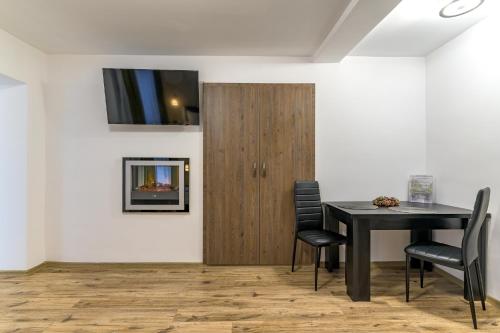 a dining room with a table and chairs and a television at Apartment Queen Bridge in Sibiu