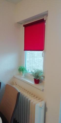 a window with a radiator and a red window shade at Apartment M&A in Osijek