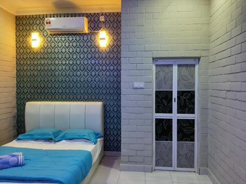 two beds in a room with a wall with a door at GekQ Inn Langkawi in Pantai Cenang