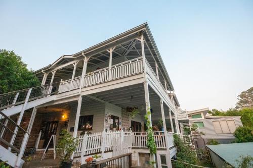 a large white house with a large balcony at Bellingen Belfry Guesthouse in Bellingen