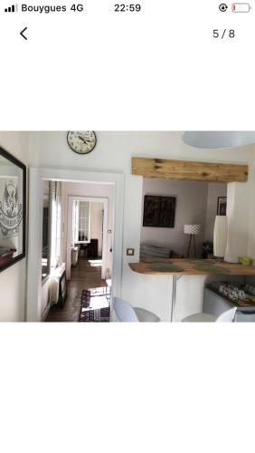 Maison cocooning avec petit jardin privatif في ليموج: مطبخ وغرفة معيشة مع طاولة وكراسي