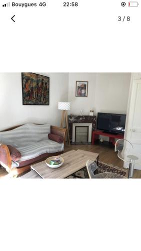 een woonkamer met een bed en een tafel bij Maison cocooning avec petit jardin privatif in Limoges