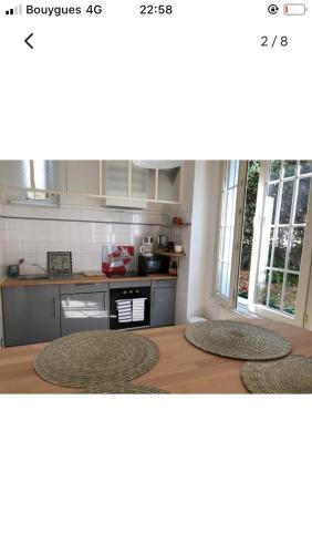 a kitchen with a stove and a counter top at Maison cocooning avec petit jardin privatif in Limoges