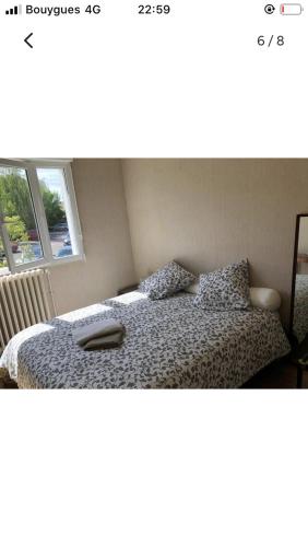 1 dormitorio con 1 cama con mando a distancia en Maison cocooning avec petit jardin privatif, en Limoges