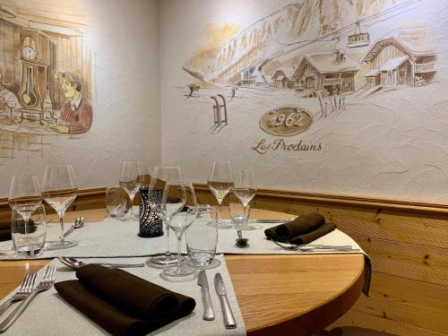 a table in a restaurant with wine glasses on it at Hameau des Prodains - Hôtel in Morzine