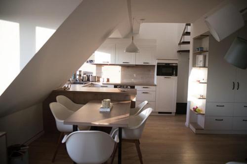 eine Küche mit einem Holztisch und weißen Stühlen in der Unterkunft Eiland Wangerooge in Wangerooge