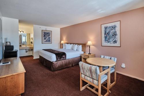 a hotel room with a bed and a table at Adventure Inn Durango in Durango