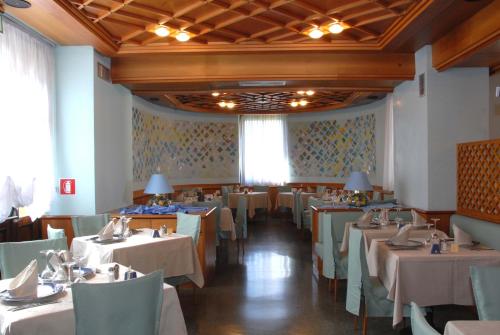 a dining room with tables and chairs in a restaurant at Grand Hotel Astoria in Lavarone