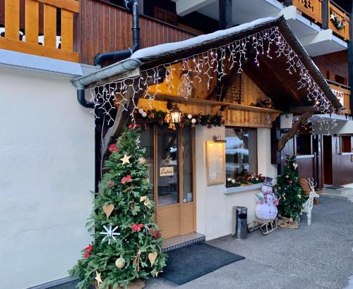 a store front with christmas trees outside of it at Hameau des Prodains - Hôtel in Morzine