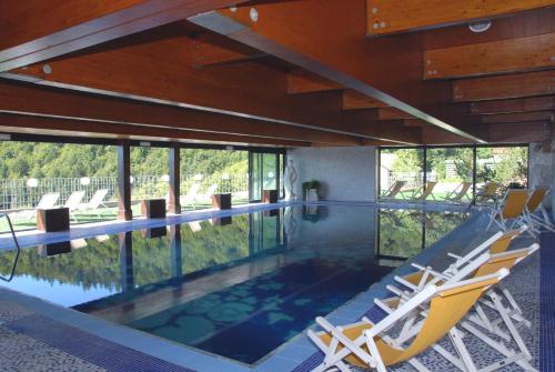 una piscina con due sedie a sdraio in una casa di Grand Hotel Astoria a Lavarone