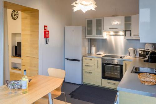 a kitchen with a table and a white refrigerator at Marketplace Apartment 2 in Ponta Delgada