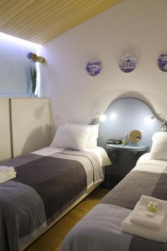 a bedroom with two beds and a table with a mirror at Marketplace Apartment 2 in Ponta Delgada