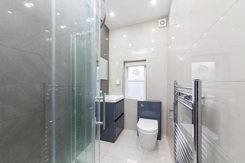 ロンドンにあるPaddington Bliss Suiteのバスルーム(シャワー、トイレ、シンク付)