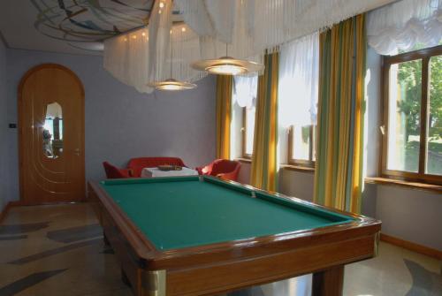 a pool table in a room with red chairs at Grand Hotel Astoria in Lavarone