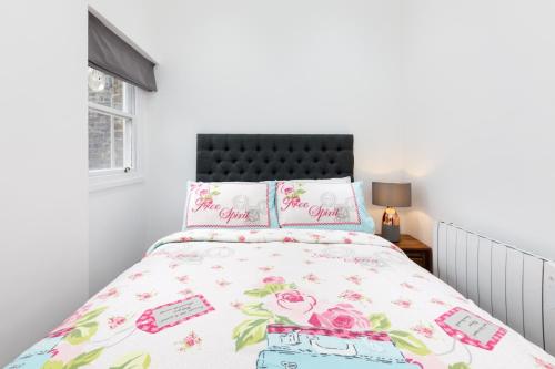 ロンドンにあるPaddington Bliss Suiteのベッドルーム1室(花柄のベッドカバー付)