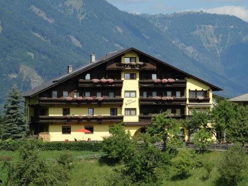 um grande edifício amarelo com montanhas ao fundo em Appartement Haus Seerose em Reith im Alpbachtal