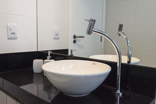 a bathroom with a white bowl sink on a black counter at Luxo Vista Mar a 50 m da Praia nos Ingleses ING9302 in Florianópolis