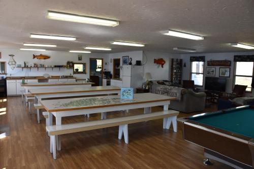 ein Zimmer mit mehreren Tischen und einem Billardtisch in der Unterkunft Zachar Bay Lodge in Kodiak