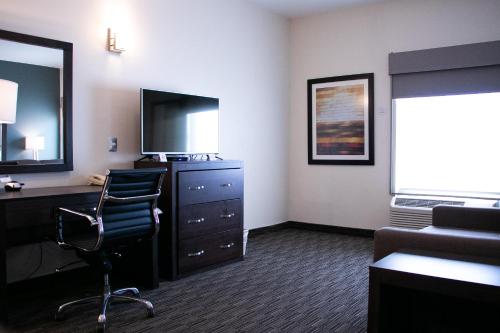 a hotel room with a desk and a chair and a television at Best Western Plus Chihuahua Juventud in Chihuahua