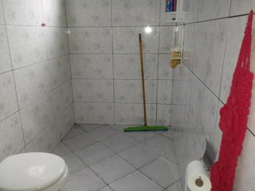 a bathroom with a toilet and a mop at Casa Beija-flor in Cavalcante