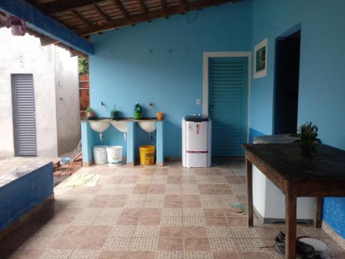 a room with a blue wall and a refrigerator at Casa Beija-flor in Cavalcante