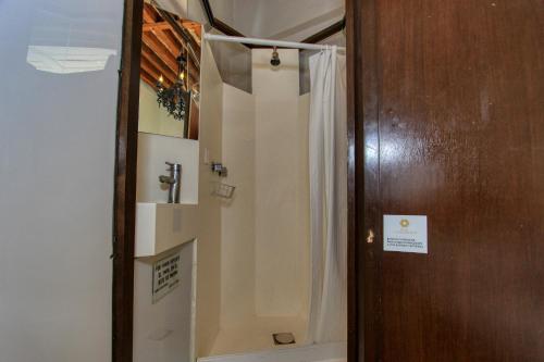 a bathroom with a shower with a white shower curtain at Hotel Mansion Von Humboldt in Guanajuato