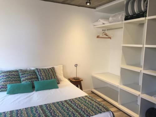 1 dormitorio con 1 cama con almohadas y estanterías verdes en Altos de Mar y Sol en Mar del Plata