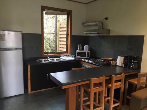 a kitchen with a black counter top and a refrigerator at Loft Pucon in Pucón