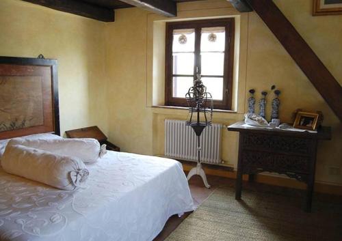 a bedroom with a white bed and a window at Villa Poggio Aperto in Seggiano